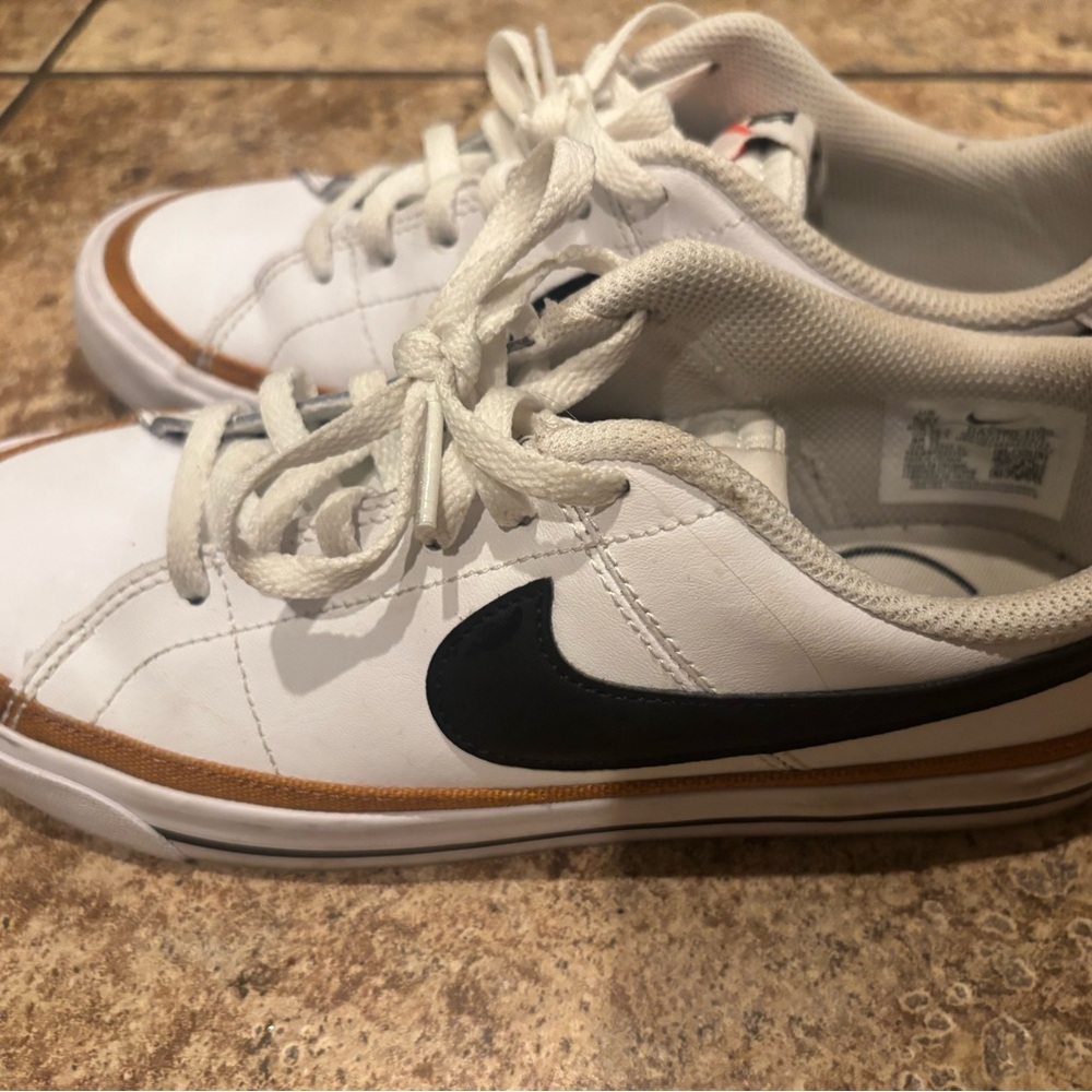 Nike White Low-Top Sneakers with Black Swoosh and Brown Accent